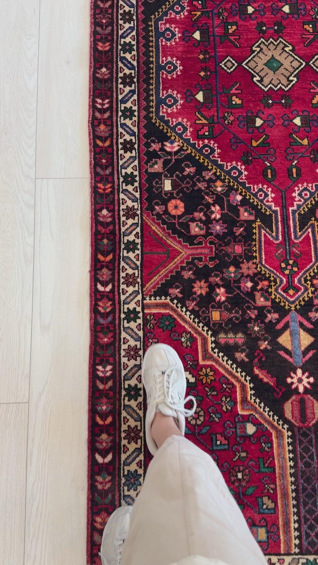 Close-up of foot on Hand-Knotted Vintage Wool Runner Rug – 9' 3" x 3' 5", highlighting the detailed border and rich red and black tones.