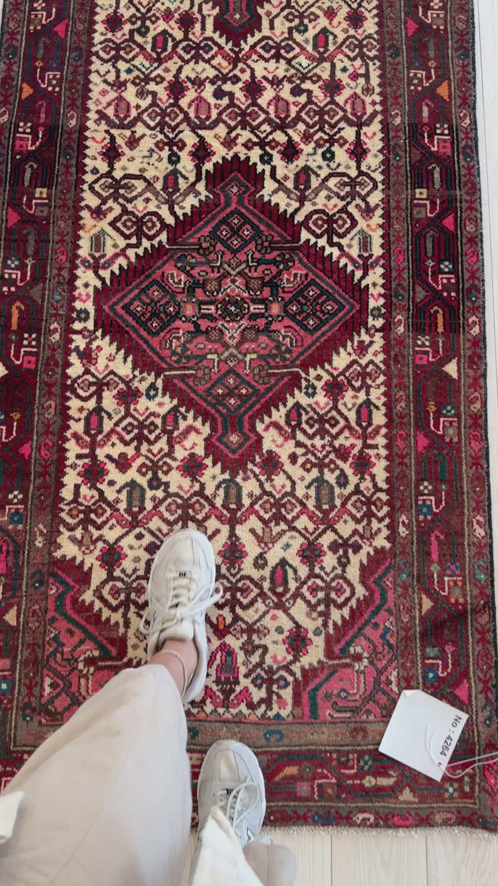 Close-up of hand-knotted wool runner rug with detailed tribal patterns and rich red tones, perfect for hallway or entryway decor.