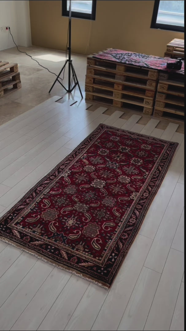 Hand-Knotted Vintage Wool Area Rug – 7' 10" x 3' 9" displayed in a studio setting with natural light, illustrating its size and rich color palette.