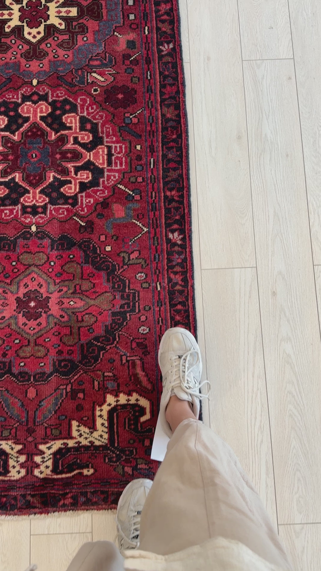 Close-up of Hand-Knotted Vintage Wool Runner Rug – 9' x 2' 7" underfoot, highlighting its rich red tones and traditional motifs on a light wood floor.